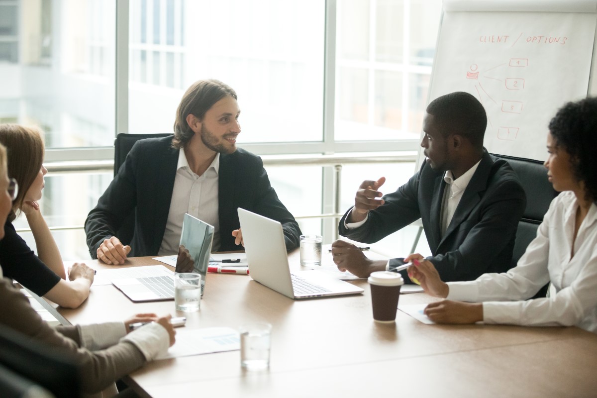 Group of business executives discussing project ideas around a conference table