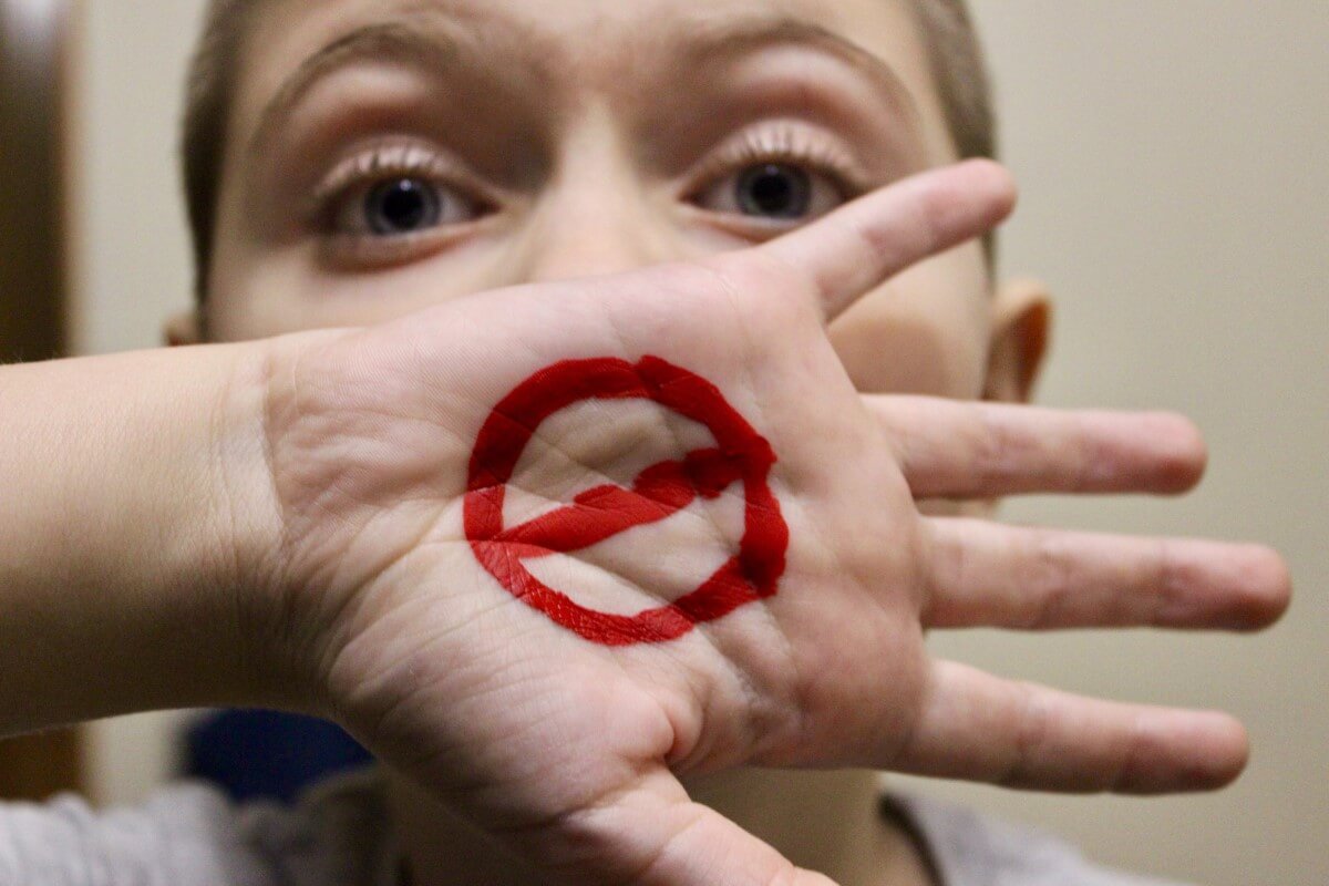 Child showing a symbol on his hand