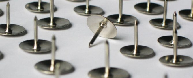 Metal thumbtacks on a white background